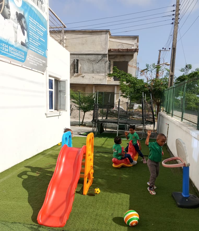 Open outdoor play area with safe equipment and green space